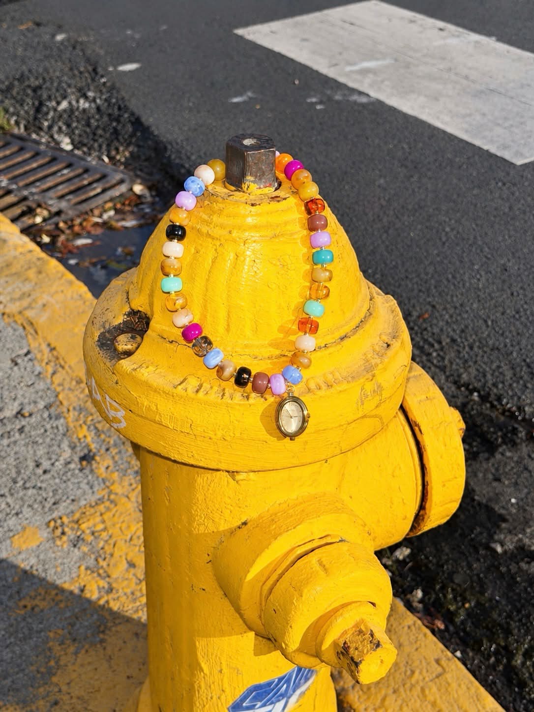 Calipso Watch Necklace styled on a yellow fire hydrant