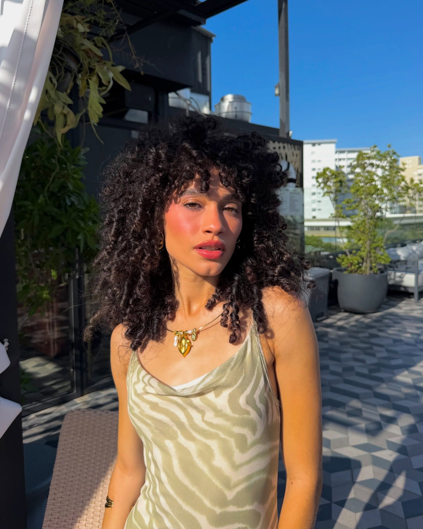 Client wearing the EARTH PLUS FIRE Soleil Watch Necklace in gold outdoors